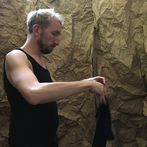 Performer is folding black clothes 